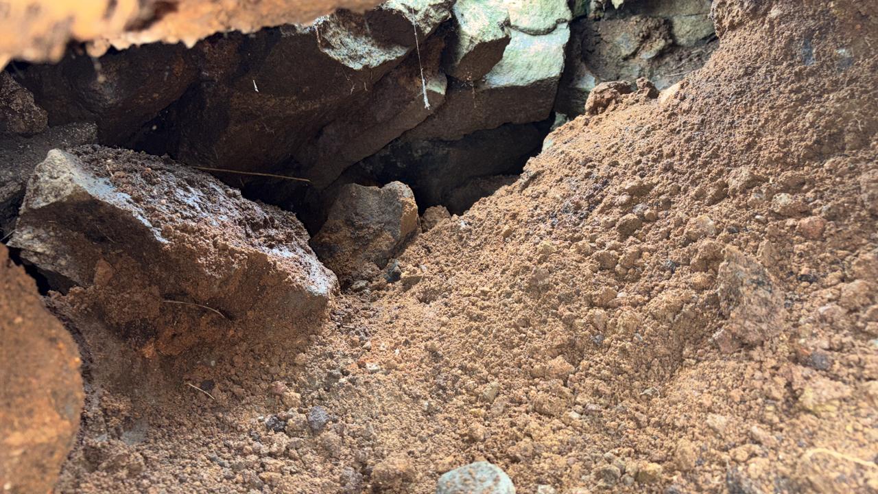 Loose stone and soil sitting above an open void in the dam wall