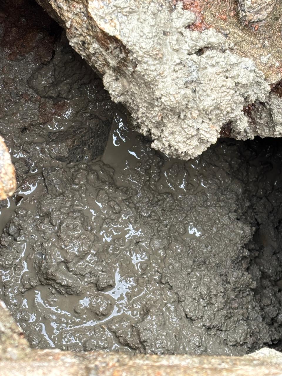 Concrete filling the void beneath the dam wall stonework